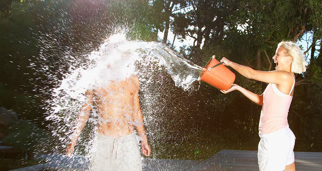Девушка обливает себя водой из шланга